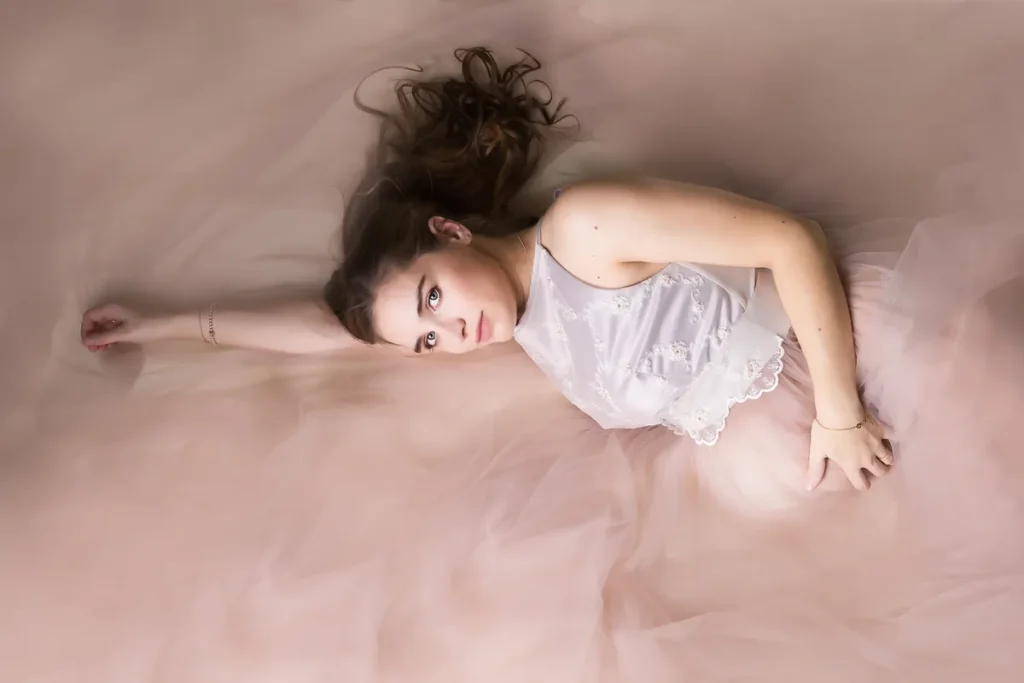 Liegende Schwangere vor rosa Grund