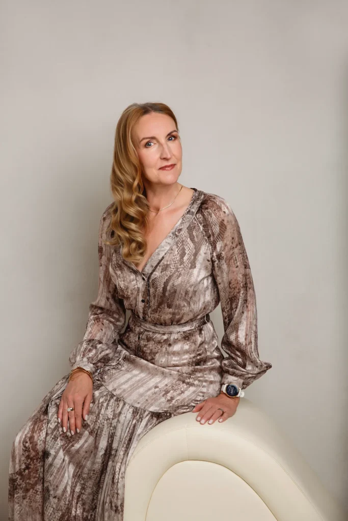 Frau ab 50 im gemusterten Kleid auf der Chaiselongue