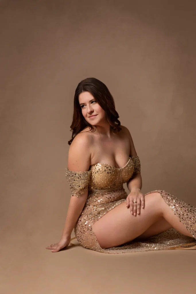 Frau im Goldkleid vor beigem Grund, Hochformat