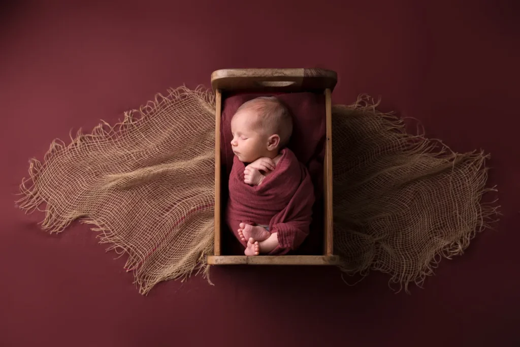 Baby in kleiner Kiste auf Bordeaux