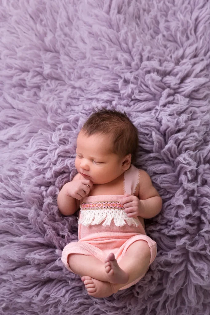 Baby in Rosa auf lila Untergrund